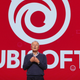 Ubisoft CEO Yves Guillemot standing on a stage at E3 in front of the company's logo.